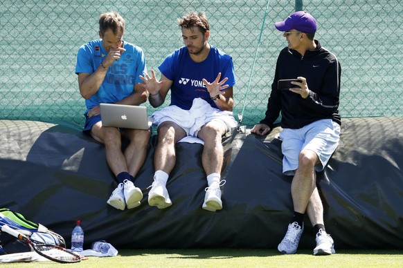 Stan Wawrinka of Switzerland, center, in discussion with his coaches Paul Annacone, right, and Magnus Norman, left, during a training session at the All England Lawn Tennis Championships in Wimbledon, ...