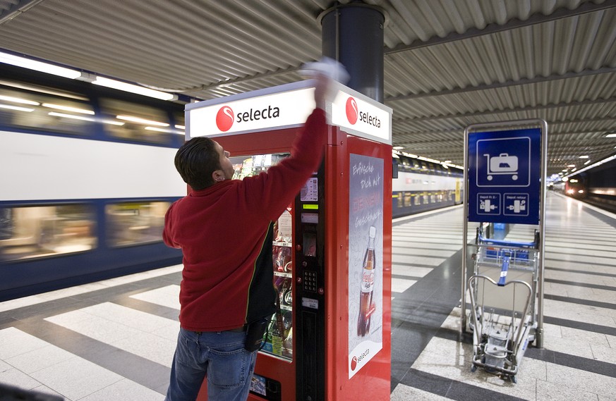 An employee of Selecta cleans a Selecta snack vending machine in the underground part of the main train station in Zurich, Switzerland, pictured on January 20, 2009. (KEYSTONE/Gaetan Bally)

Ein Mitar ...