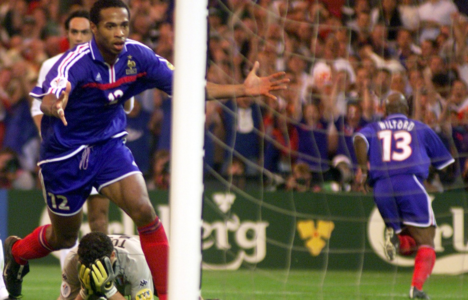 France&#039;s Thierry Henry celebrates Sylvain Wiltord&#039;s goal, right, as Italy&#039;s goalkeeper Francesco Toldo holds his head in his hands during the final of the EURO 2000 soccer championships ...