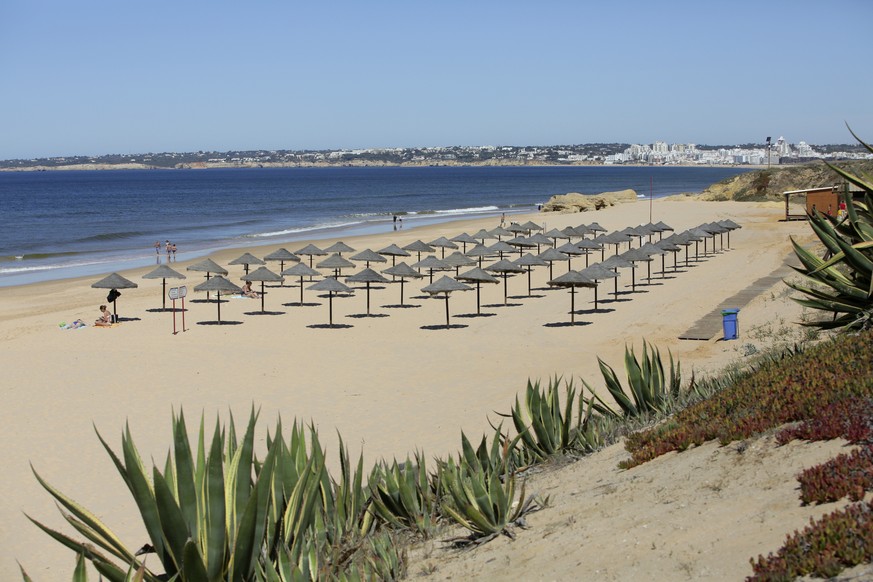 Empty sunshades wait for customers at Gale beach in Albufeira, in Portugal&#039;s southern Algarve region, Tuesday, May 18, 2021. British vacationers began arriving in large numbers in southern Portug ...
