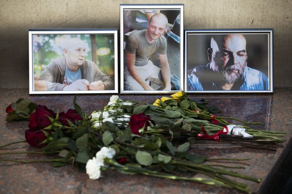 Flowers are placed by portraits of slain journalists Alexander Rastorguyev, Kirill Radchenko and Orkhan Dzhemal, at the Russian journalists Union building in Moscow, Russia, Wednesday, Aug. 1, 2018. R ...