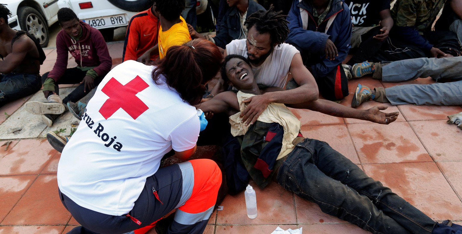 A Spanish Red Cross worker aids African migrants after they crossed a border fence between Morocco and Spain&#039;s north African enclave of Ceuta October 31, 2016. REUTERS/M. Martin FOR EDITORIAL USE ...