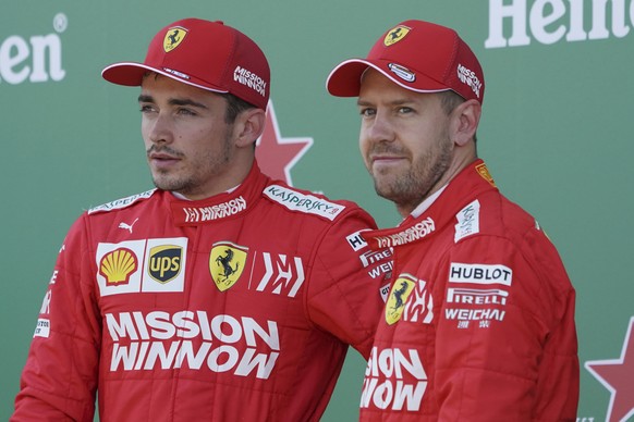 FILE - In this file photo taken on Oct. 13, 2019, Ferrari driver Sebastian Vettel of Germany stands with teammate Charles Leclerc, left, of Monaco after the qualifying session for the Japanese Formula ...