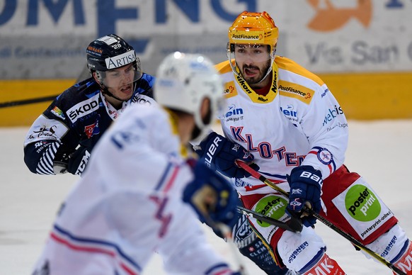 Kloten&#039;s Topscorer Denis Hollenstein, right, fights for the puck with Ambri&#039;s player Eliot Berthon, left, during the fifth match of the playout final of the National League Swiss Championshi ...