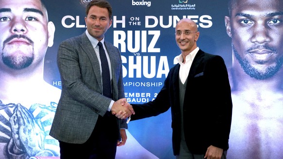 Boxing promoters Eddie Hearn and managing partner of Skill Challenge Entertainment Omar Khalil shake hands, during a press conference at The Savoy Hotel, London, Monday, Aug. 12, 2019. Anthony Joshua& ...