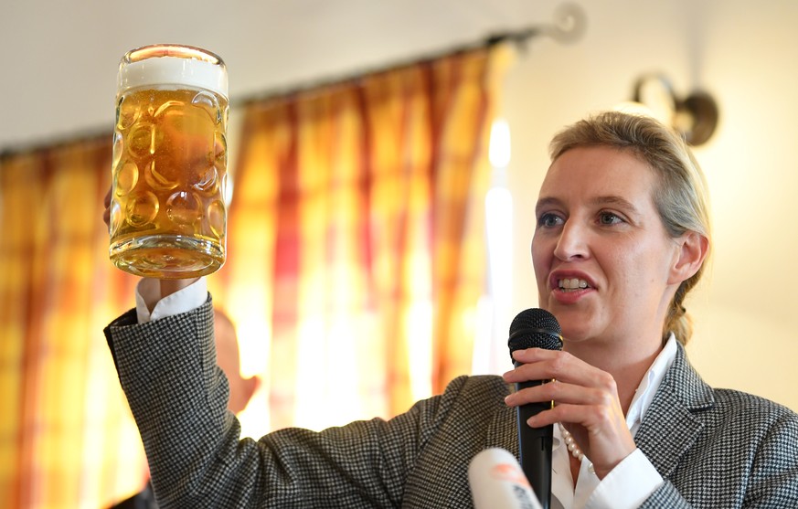 epa07090274 Chairman of the Alternative for Germany party (AfD) faction Alice Weidel holds a glass of beer during an election campaign rally in Taufkirchen (Vils), Bavaria, Germany, 13 October 2018. A ...