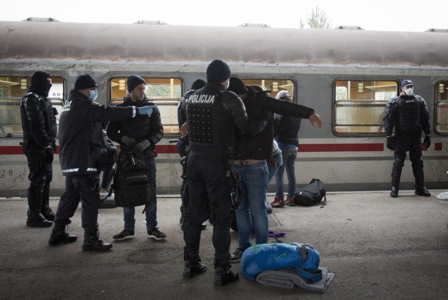 Flüchtlinge werden nach der Ankunft aus Kroatien am Bahnhof in Dobova kontrolliert.