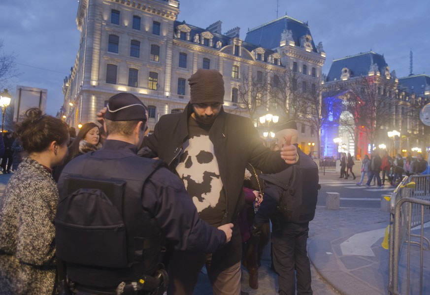 Polizisten durchsuchen einen Mann in Paris, 24. Dezember 2015.