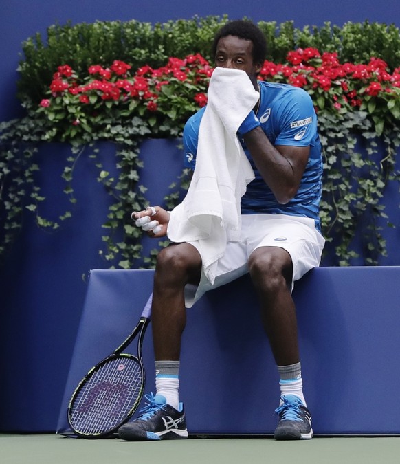 Gael Monfils, of France, wipes sweat from his face between serves from Novak Djokovic, of Serbia, during the semifinals of the U.S. Open tennis tournament, Friday, Sept. 9, 2016, in New York. (AP Phot ...