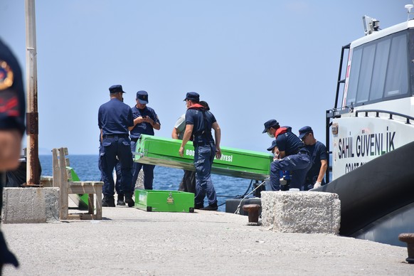 epa07654571 Turkish Coast Guard members carry a coffin of a migrant who died after a boat sunk in the Aegean sea off Bodrum disrict in Mugla, Turkey, 17 June 2019. According to media reports 12 migran ...