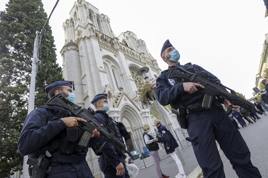 French police officers stand near Notre Dame church in Nice, southern France, Thursday, Oct. 29, 2020. French President Emmanuel Macron has announced that he will more than double number of soldiers d ...