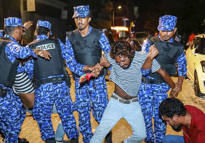 Maldivian police officers detain an opposition protestor demanding the release of political prisoners during a protest in Male, Maldives, Friday, Feb. 2, 2018. Opponents of the Maldives government cla ...