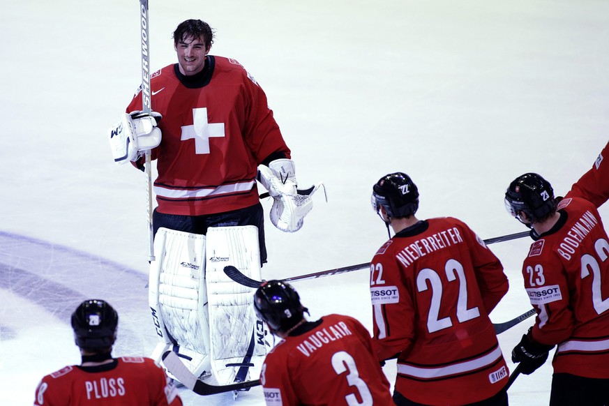 Switzerland&#039;s goaltender Reto Berra, top, is celebrated by his teammates, from left, Martin Pluess, Julien Vauclair, Nino Niederreiter and Simon Bodenmann, after their victory over USA, during th ...