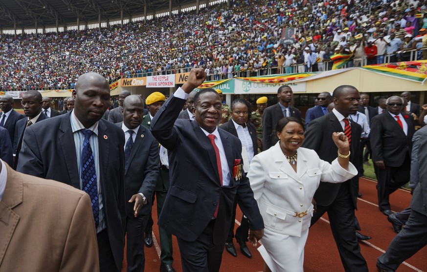Emmerson Mnangagwa, center, and his wife Auxillia, center-right, arrive at the presidential inauguration ceremony in the capital Harare, Zimbabwe, Friday, Nov. 24, 2017. Mnangagwa is being sworn in as ...
