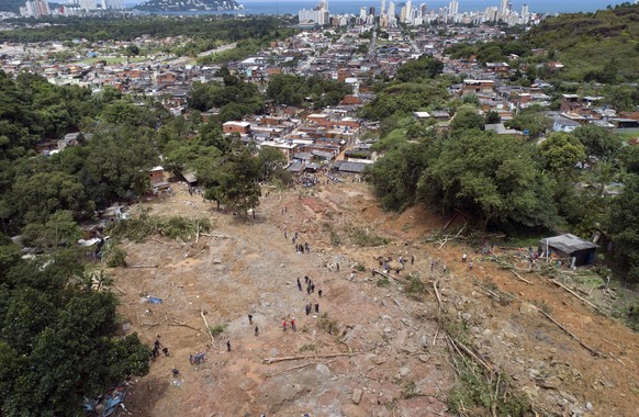 Rescue workers, residents, and volunteers search for victims after a mudslide caused by heavy rains in the coastal city of Guaruja, Brazil, Wednesday, March 4, 2020. Storms have pummeled BrazilÄôs so ...