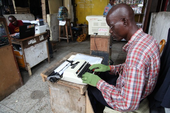 Ein liberianischer Angestellter versucht sich mit Handschuhen gegen das Virus zu schützen.