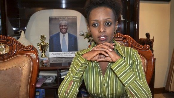 In this photo taken Sunday, May 14, 2017, women&#039;s rights activist and presidential candidate Diane Shima Rwigara, 35, is photographed next to a portrait of her father, business tycoon Assinapol R ...