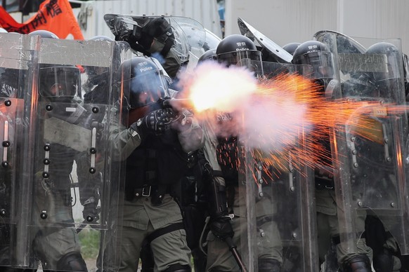 epa07891105 Riot police fire tear gas during a mass rally in Yuen Long, New Territories, Hong Kong, China, 27 July 2019. Anti-extradition bill protesters took to the streets to denounce the break out  ...