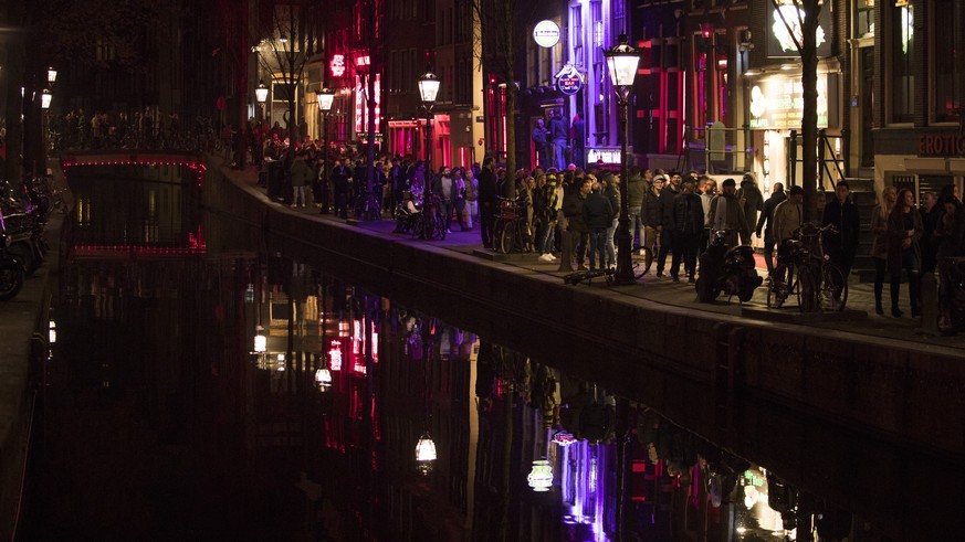 Tourists crowded the narrow canal-side streets in Amsterdam&#039;s red light district, Netherlands, Friday evening, March 29, 2019. The Dutch capital plans to ban guided tours of the red light distric ...