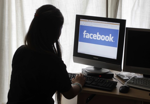 FILE - In this Monday, June 4, 2012, file photo, a girl looks at Facebook on her computer in Palo Alto, Calif. Most teenagers have taken a break from social media, according a new poll from The Associ ...