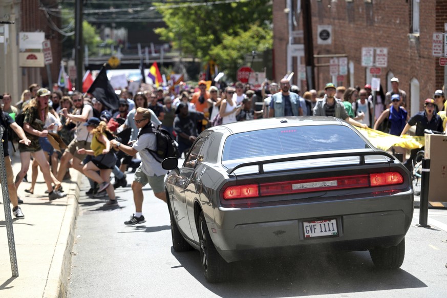 A vehicle drives into a group of protesters demonstrating against a white nationalist rally in Charlottesville, Va., Saturday, Aug. 12, 2017. The nationalists were holding the rally to protest plans b ...