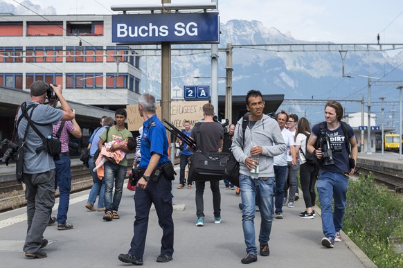 Asylanten werden von Polizei und Medien zum Polizeiposten begleitet. 5 Asylanten, 2 Kinder ein Elternpaar und ein junger Mann, kommen mit dem Railjet Zug von Wien her auf dem Bahnhof in Buchs SG an un ...