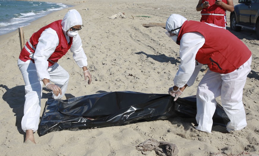 Libyan Red Crescent workers pick up a body of a drowned migrant near the city of Khoms, some 100 kilometers (60 miles) east of Tripoli, Libya, Friday, July 26, 2019. Libya&#039;s coast guard recovered ...