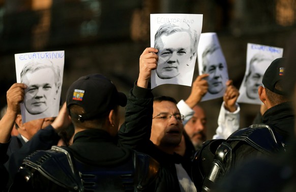 epa07134379 People hold posters with images of WikiLeaks founder Julian Assange during a support rally in front of the Carondelet Palace in Quito, Ecuador, 31 October 2018. Supporters of former Ecuado ...