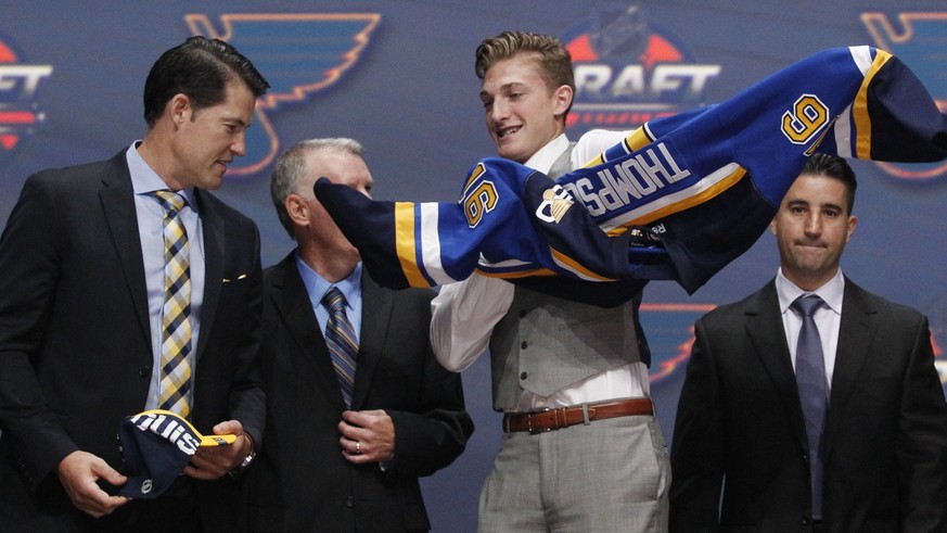 Jun 24, 2016; Buffalo, NY, USA; Tage Thompson puts on a team jersey after being selected as the number twenty-six overall draft pick by the St. Louis Blues in the first round of the 2016 NHL Draft at  ...