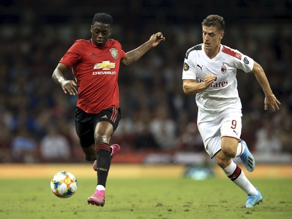 Manchester United&#039;s Aaron Wan-Bissaka, left, and AC Milan&#039;s Krzysztof Piatek battle for the ball during the Pre-Season match between Manchester United and AC Milan at the Principality Stadiu ...