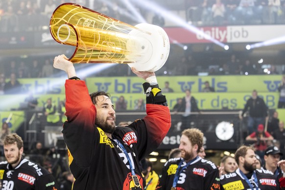 Berns Simon Moser feiert mit dem Pokal den Schweizermeistertitel nach dem Sieg im fuenften Eishockey Playoff-Finalspiel der National League zwischen dem SC Bern und dem EV Zug, am Samstag, 20. April 2 ...