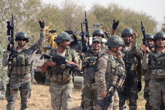 In this Monday, Oct. 14, 2019 photo, Turkish troops deploy in Syria&#039;s northern region of Manbij. Syrian state media said Tuesday that government forces have entered the center of the once Kurdish ...