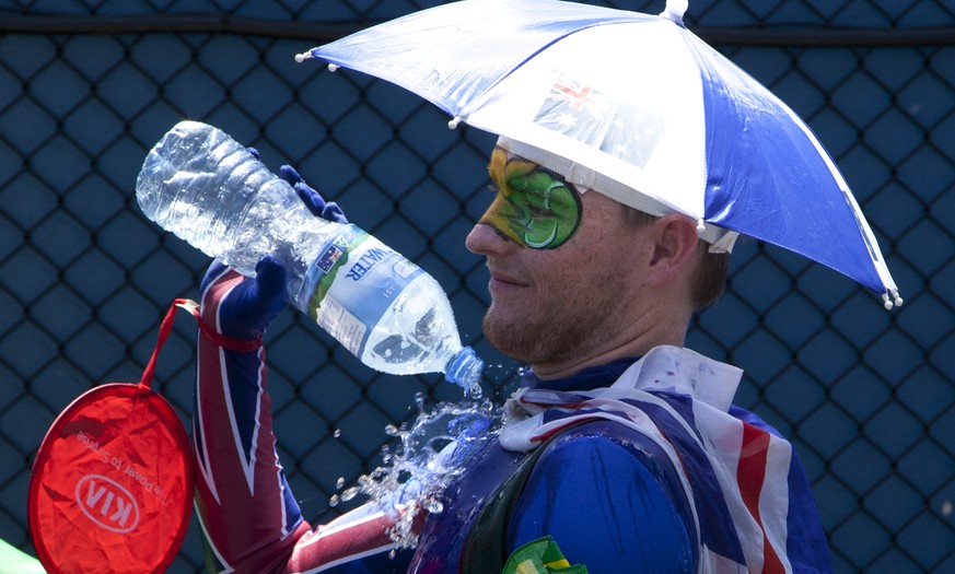 A spectators pours water over himself to cool down as play was suspended when organizers implemented the Extreme Heat policy during second round matches at the Australian Open tennis championship in M ...