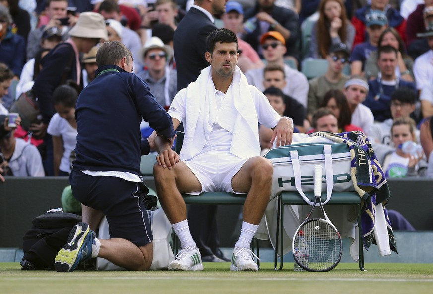 Novak Djokovic receives medical treatment during his Men&#039;s Singles Match against Tomas Berdych on day nine of the Wimbledon Tennis Championships at The All England Lawn Tennis and Croquet Club, L ...