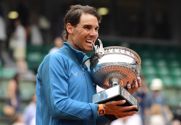 epa06799093 Rafael Nadal of Spain celebrates with the trophy after winning his 11th French Open title against Dominic Thiem of Austria during their men’s final match during the French Open tennis tour ...