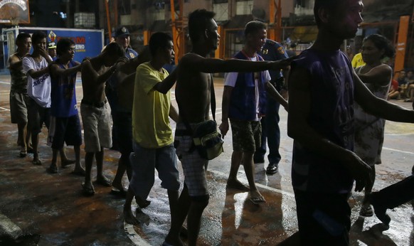 Police round up residents, during a police &quot;One Time Big Time&quot; operation in the continuing &quot;War on Drugs&quot; campaign of President Rodrigo Duterte at slum community of Tondo in Manila ...