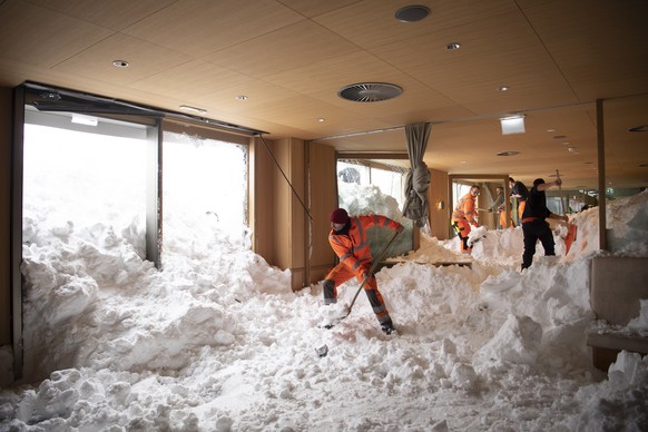 epa07275741 Emergency service workers clear snow from the inside of the Hotel Saentis on the Schwaegalp, Switzerland, after an avalanche came down, in Hundwil, Switzerland, 11 January 2019. According  ...