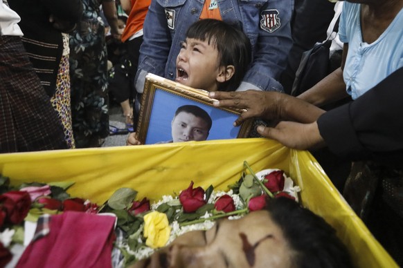 epa09053111 The daughter of Zwee Htet Soe, one of the three demonstrators who died in the anti-coup protests, cries near the coffin of her father during his funeral in Yangon, Myanmar, 05 March 2021.  ...