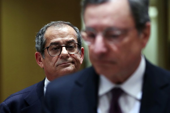 Italian Finance Minister Giovanni Tria, background, and European Central Bank President Mario Draghi enter the chamber after a break during a meeting of Eurogroup Finance Ministers at the European Cou ...