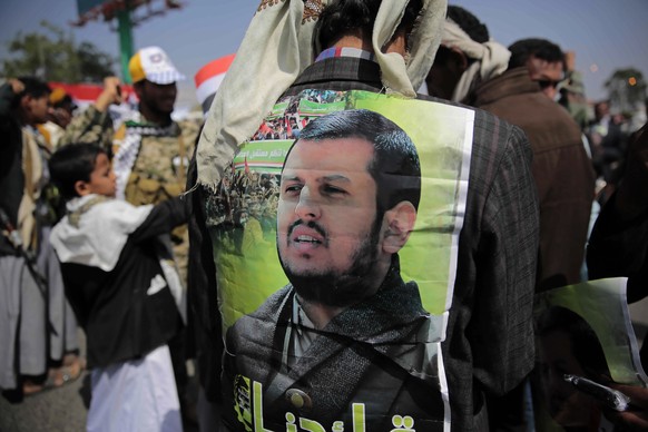 A Supporter of Houthi Shiites displays a poster of Abdel-Malek al-Houthi, the leader of Yemen&#039;s Shiite rebels, on his jacket during a rally to mark the third anniversary of the Houthis&#039; take ...