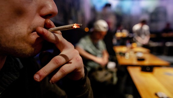epa07523295 A man smokes a weed joint in Cremers coffee shop, in The Hague, the Netherlands, 22 April 2019 (issued 23 April 2019). In the Netherlands, an experiment with state-regulated marijuana cult ...