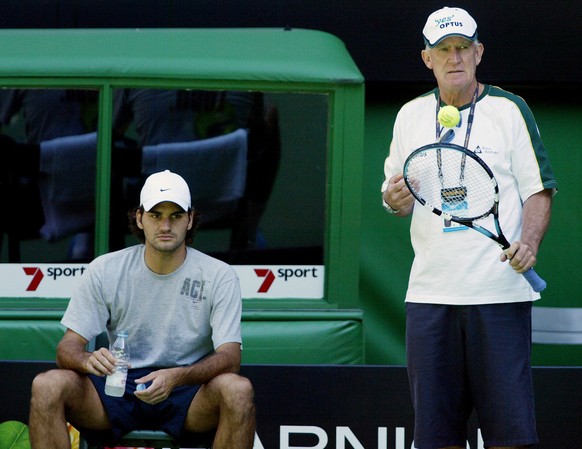 Switzerland&#039;s Roger Federer, left, sits in a courtside chair as his coach Australian Tony Roche looks on during a practice session on Rod Laver Arena at the Australian Open at Melbourne Park, Mel ...