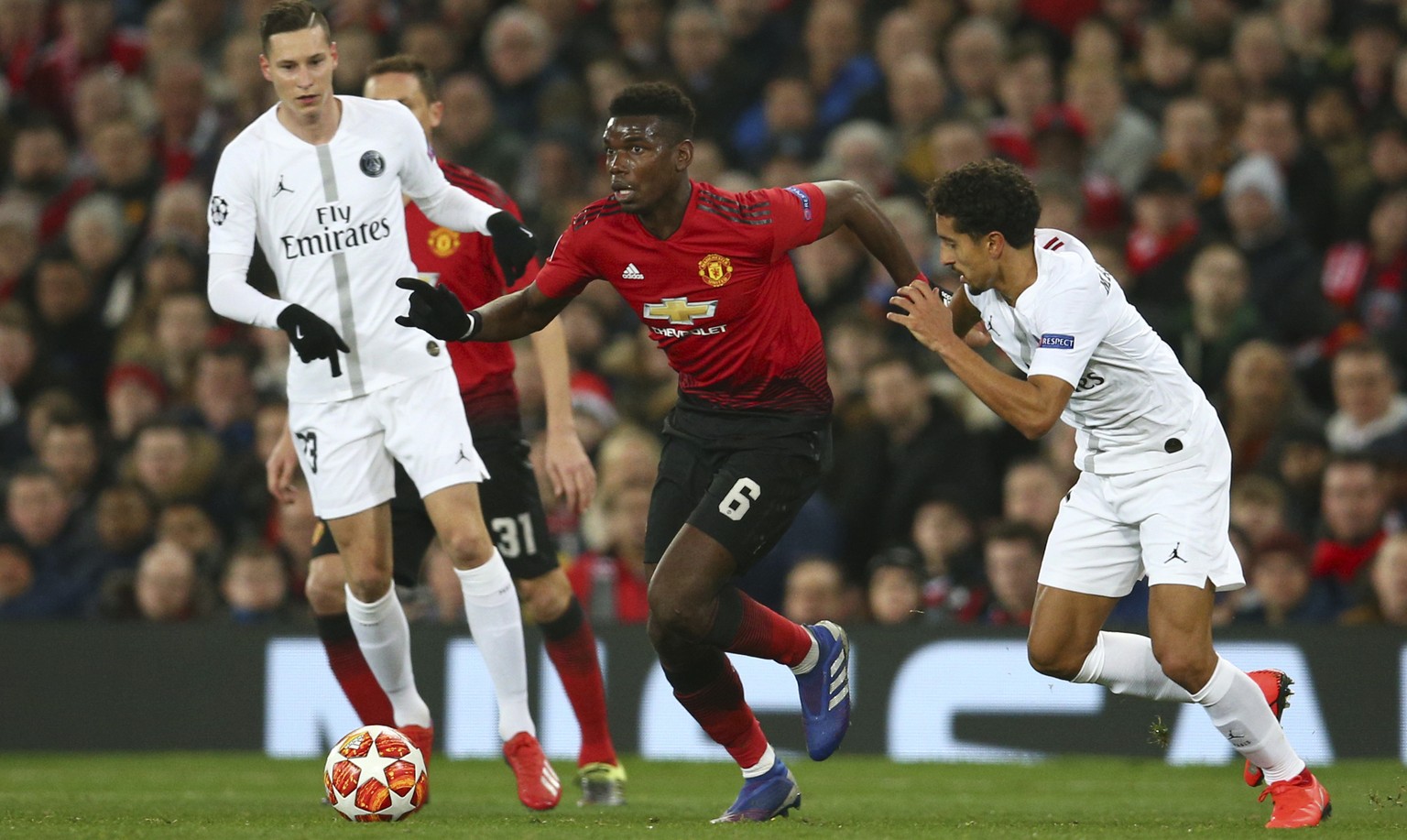 Manchester United&#039;s Paul Pogba, centre, vies for the ball with Paris Saint Germain&#039;s Marcos Marquinhos, right, during the Champions League round of 16 soccer match between Manchester United  ...