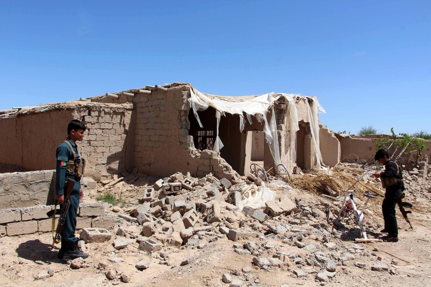 epa05896788 Members of the Afghan security forces survey a house that was damaged during an operation against Taliban fighters in Nad Ali district of Helmand province, Afghanistan, 08 April 2017. Afgh ...