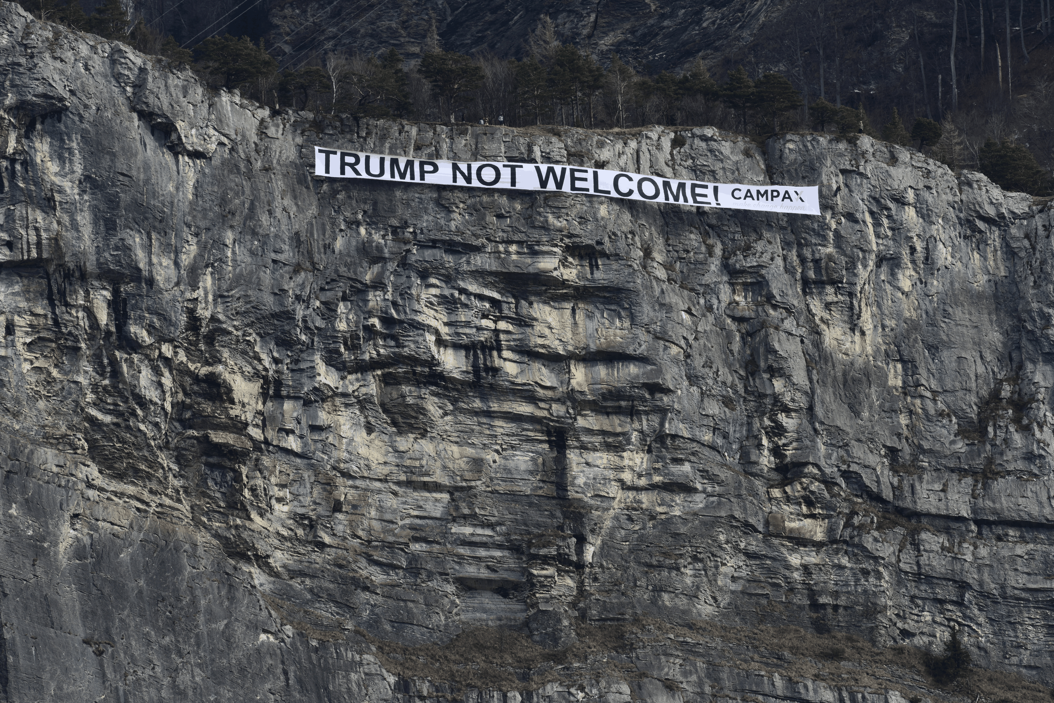 HANDOUT - A banner with the inscription &quot;Trump not welcome!&quot; is hanging in a rock face of the Ellhorn mountain near Sargans, Switzerland, on Thursday, January 25, 2018. The campaign organisa ...