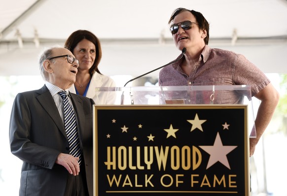 Italian composer Ennio Morricone, left, reacts as director Quentin Tarantino speaks during a ceremony presenting Morricone with a star on the Hollywood Walk of Fame on Friday, Feb. 26, 2016, in Los An ...