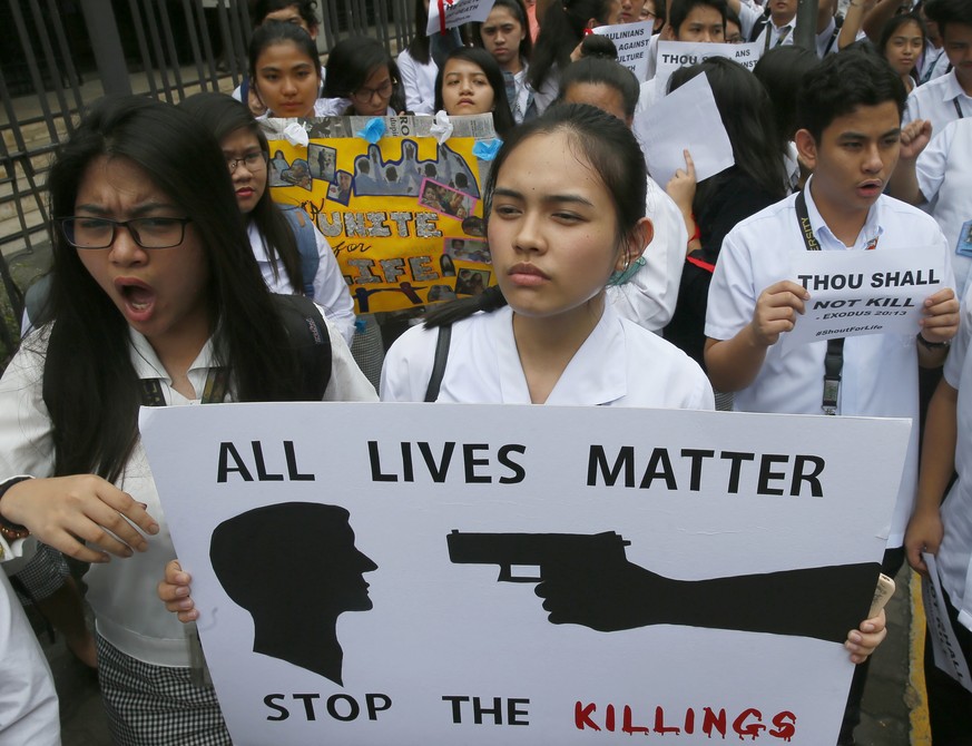 Students from St. Paul&#039;s University, a Roman Catholic university, display placards as they come out from their campus to protest the killings being perpetrated in the unrelenting &quot;War on Dru ...