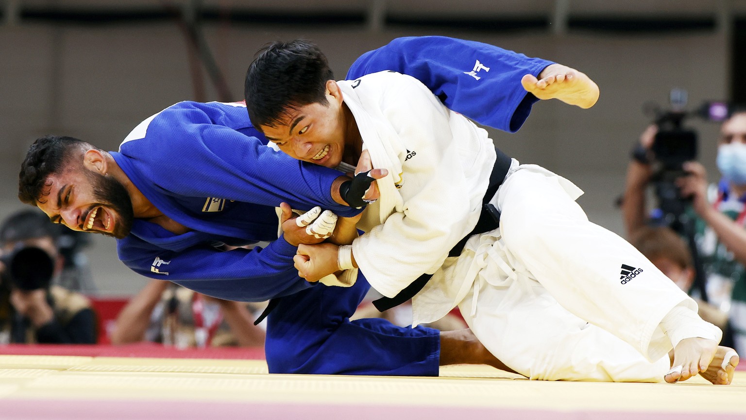 epa09366217 An Changrim (white) of South Korea in action against Tohar Butbul of Israel during their bout in the Judo Men -73kg quarter final at the Tokyo 2020 Olympic Games at the Nippon Budokan aren ...