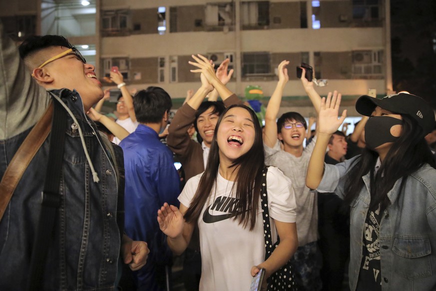 Pro-democracy supporters celebrate after pro-Beijing politician Junius Ho lost his election in Hong Kong, early Monday, Nov. 25, 2019. Vote counting was underway in Hong Kong early Monday after a mass ...
