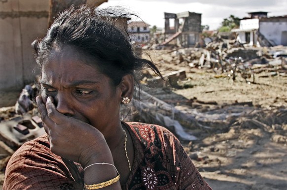 A Sri Lankan woman whose two small children were killed in last week&#039;s devastating tsunami turns away from the sight of her wrecked house after visiting her home for the first time since the tsun ...